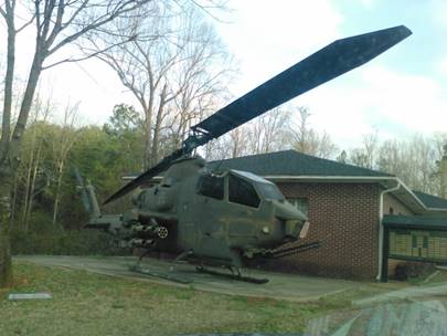 A helicopter parked in front of a house

Description automatically generated